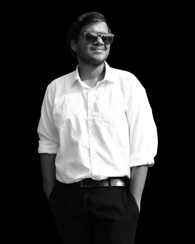 Raj Tibarewala, in a white shirt, photographed in black and white